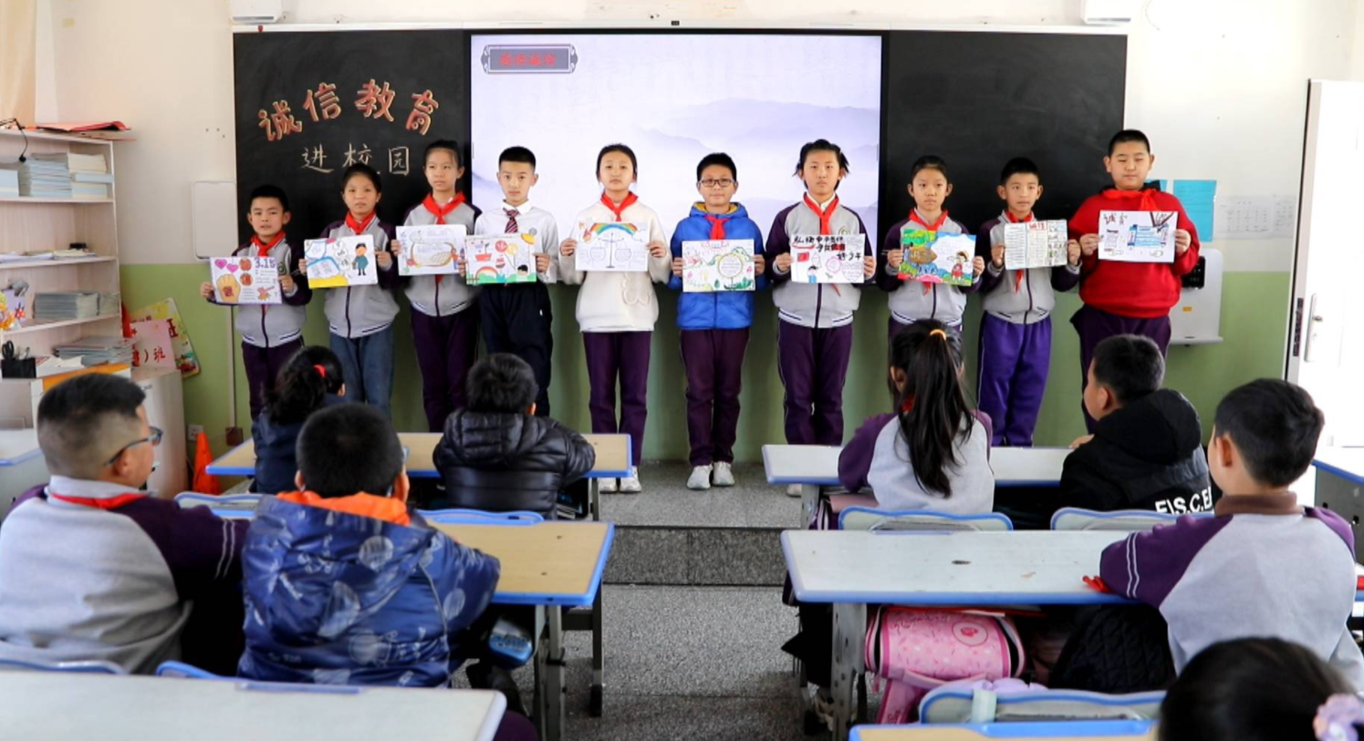 同学们齐拍手唱诚信歌,还通过诚信情景剧,小故事,分享手抄报等形式